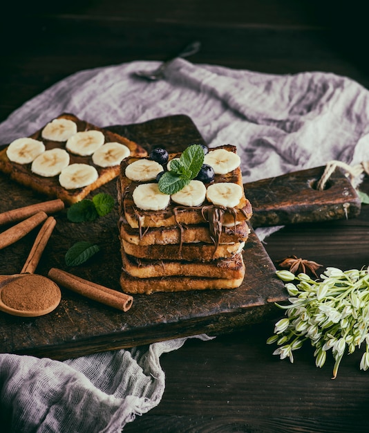 Square French toasts of white bread with chocolate and pieces of banana 