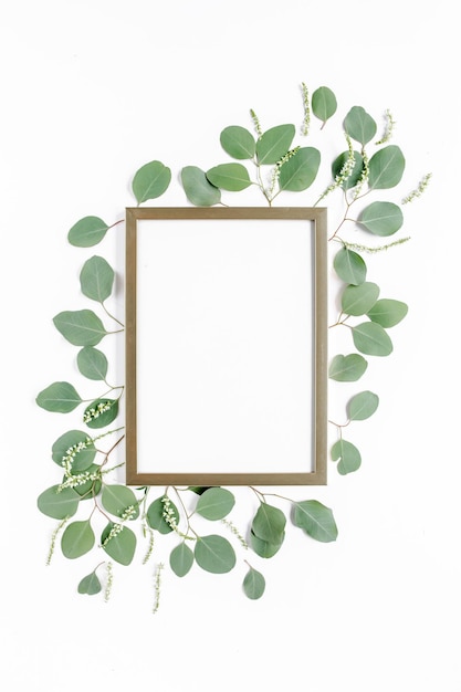 Photo square gold frame decorated with green eucalyptus leaves twigs floral pattern on a white background