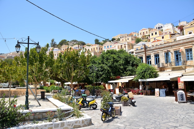 square on the greek island Symi with cafes, bikes and houses