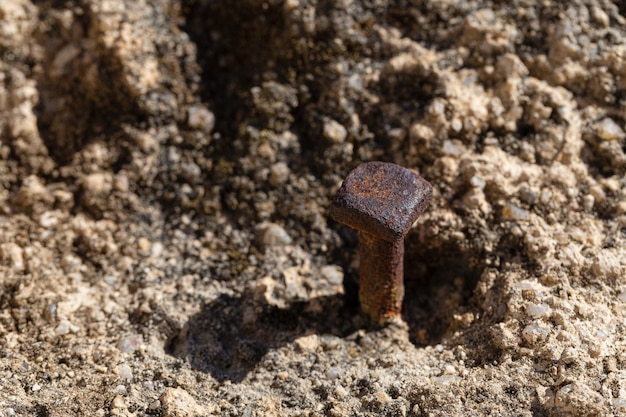 Square head masonry nail driven into a stone