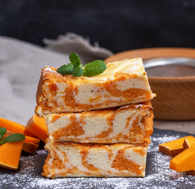 Square pieces of cheesecake with pumpkin 