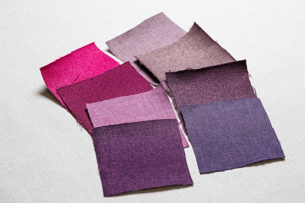 Square pieces of multi-colored fabric laid out on a gray background