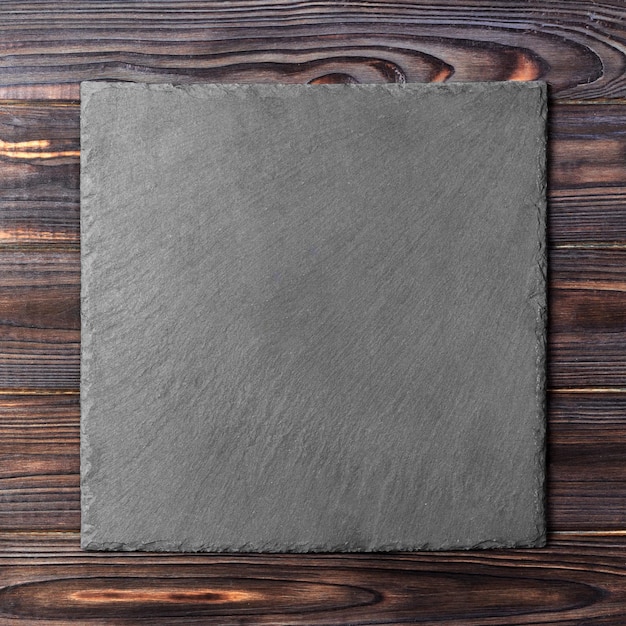 Photo square plate on table black dish on wooden background copy space