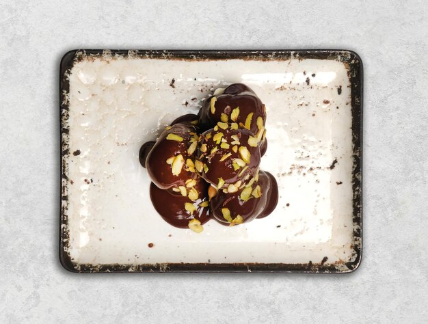 Photo a square plate with chocolate covered chocolate and nuts on it