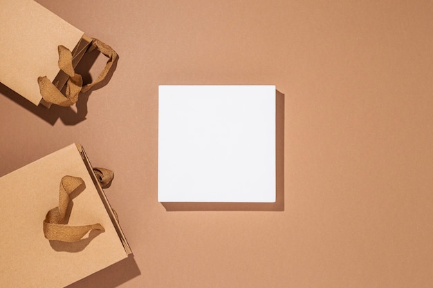 Square podium for presentation, craft packaging packages on a brown cardboard background. Top view, flat lay.