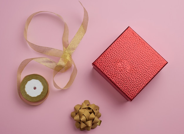 Square red box tied with a golden ribbon