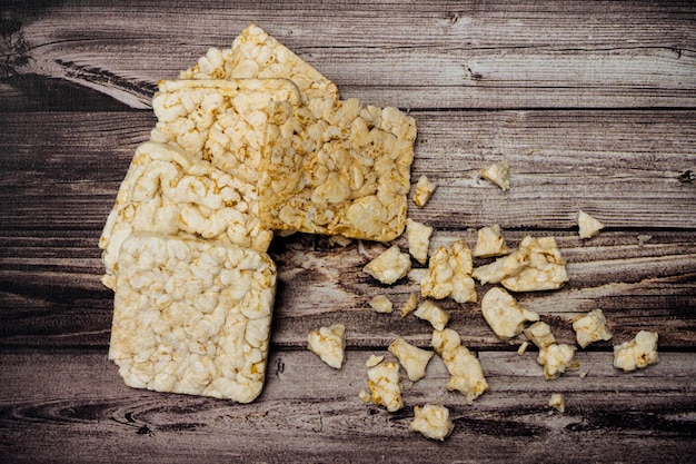 Square rice crackers on a rustic table Natural and healthy food concept