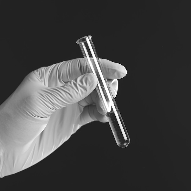 square shot of hand holding liquid in test tube close up on black background the concept of searching for an antiviral drug