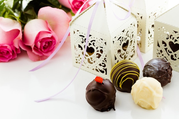 Square white decorative lace heart favor boxes filled with gourmet truffles.