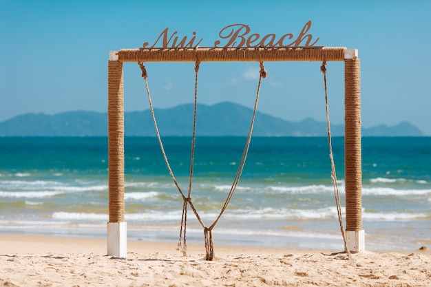 Square wooden arch on beach of ocean