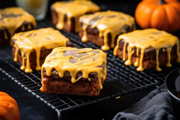 Photo squarecut halloween brownies with orange frosting on a cooling rack