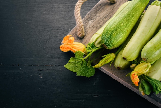 Squash Beenmerg Courgette Verse groenten Op een zwarte houten tafel Bovenaanzicht Kopieer de ruimte