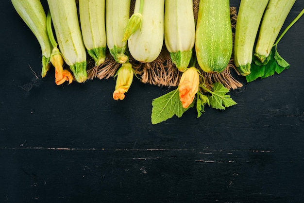 Squash Beenmerg Courgette Verse groenten Op een zwarte houten tafel Bovenaanzicht Kopieer de ruimte