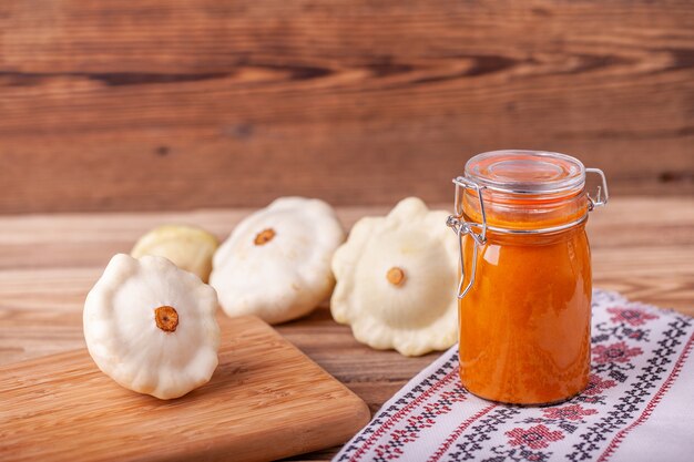 Caviale di zucca in un barattolo sul tavolo sul tavolo di legno con zucca bianca