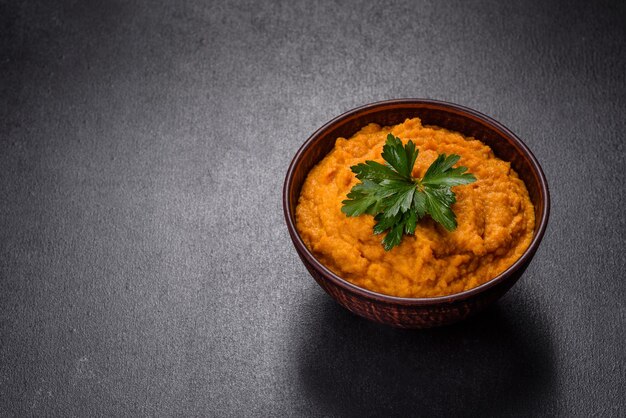 Foto caviale di zucca con aglio e pomodori in una ciotola rustica su sfondo scuro