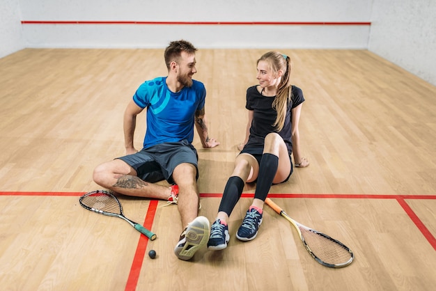 Squash game concept, young couple, rackets, ball