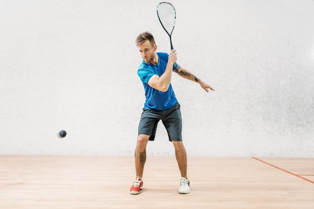 Squash game training, mannelijke speler met racket en bal