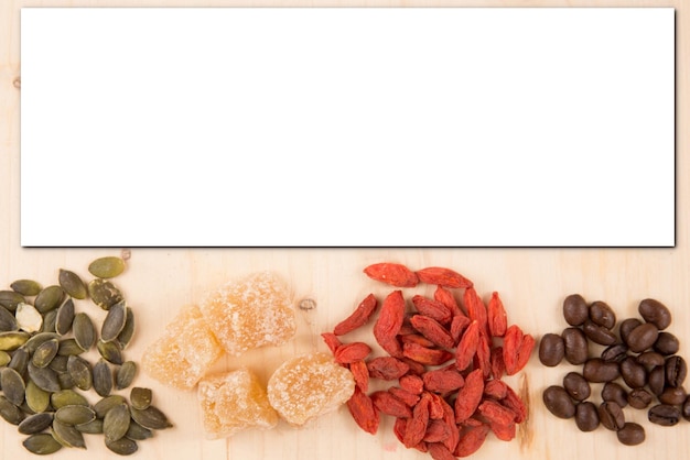 Squash goji zaad Mock Roasting Seeds koffie en gedroogd fruit houten achtergrond met blanco vel papier voor tekst Voedsel mock up lege witte kaart papier uitnodiging recept ruimte voor tekst