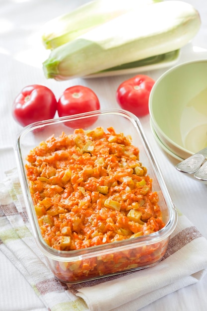 Squash stew with carrot and tomatoes in a square glass dish