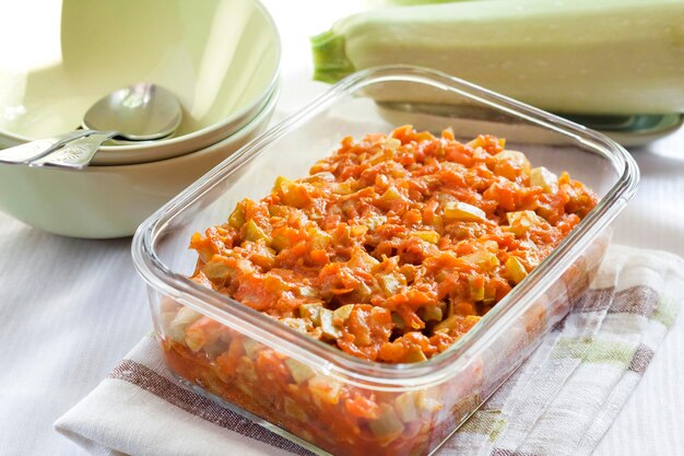 Squash stew with carrot and tomatoes in a square glass dish