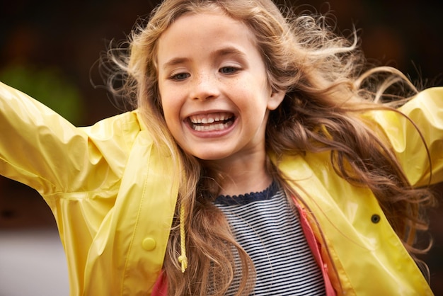 Squeal for joy Shot of a cute little girl wearing a raincoat playing outside