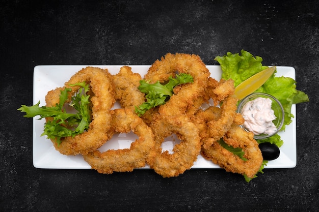 Squid rings fried in batter on a dark background soft focus