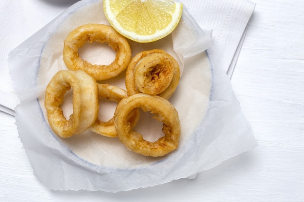 Squid rings sandwiches with mayonnaise sauce and lemon. Typical Spanish food. Bocadillo de calamares. Typical Spanish food