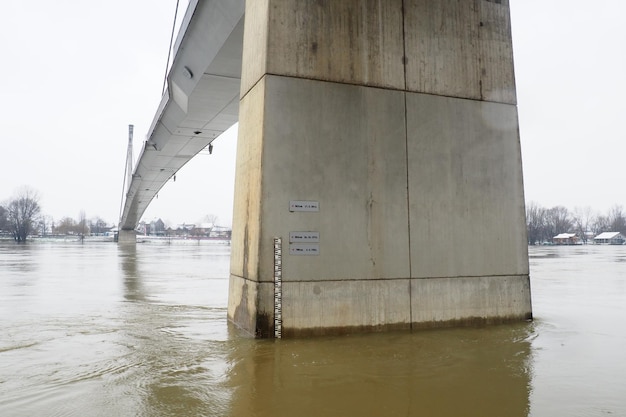 Sremska Mitrovica Servië 01272023 Brug over de rivier de Sava Overstroming na zware regenval en smeltende sneeuw Een snelle stroom modderig water Hydrologische schaal voor het meten van het waterpeil