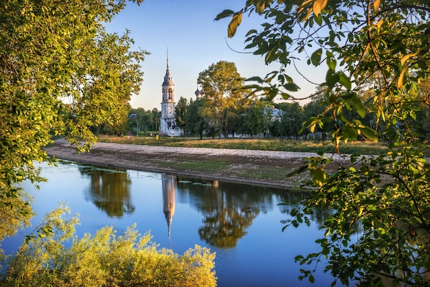 Sretenskaya-kerk aan de rivieroever en reflectie in de rivier in Vologda op een vroege zomerochtend