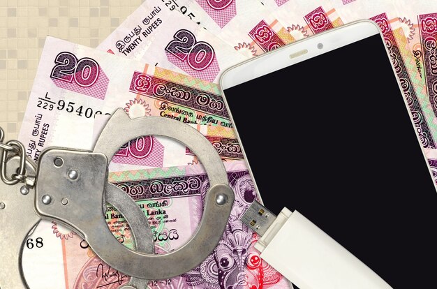 sri lankan rupees bills and smartphone with police handcuffs