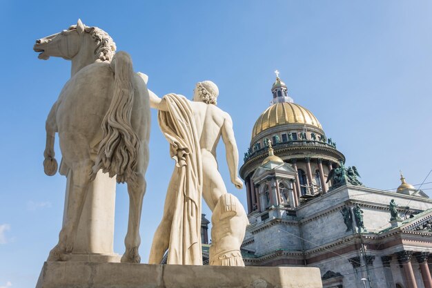 St. Isaac's Cathedral op de voorgrond een sculptuur van een mannelijke krijger met een paard in Sint-Petersburg