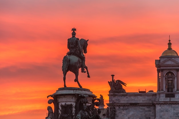 St Isaac's Cathedral in the square in St Peterburg in the evening on a bright orange sunset sky left monumentrider on horse Nikolai