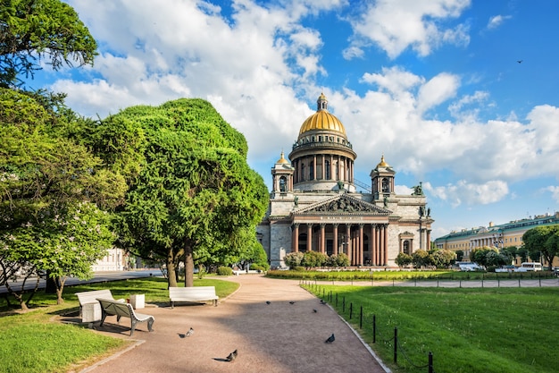 Исаакиевский собор в Санкт-Петербурге ярким солнечным утром и голуби возле скамейки