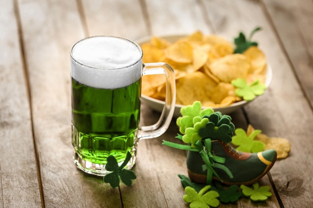 St Patrick Day-concept Glas groen bier en bord met chips op houten tafel