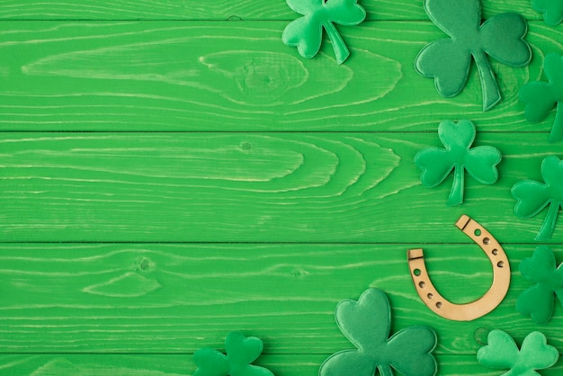 St. patrick's day congrats concept. Top above overhead close up view photo image of golden horseshoe and clover leaves isolated bright color green table desk with copy space for advert