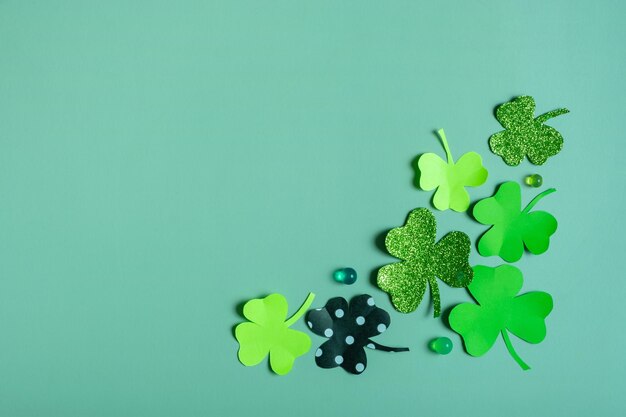 St Patrick's Day minimalistic concept Paper clover leaves on colored background with copy space