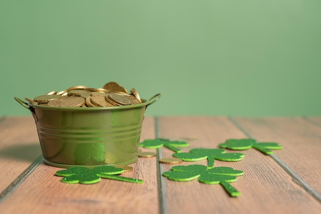 St. Patrick's Treasure Pot full of coins surrounded by lucky clovers on the table