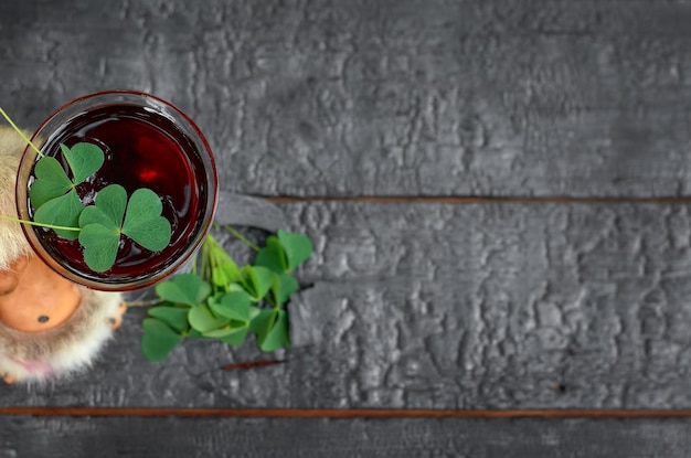 Photo st patricks day clover imp glass of wine on a wooden background