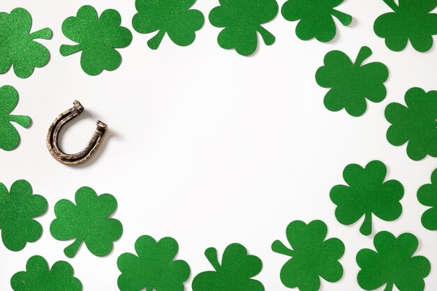 St Patricks day frame with clover leaves and horseshoe on white