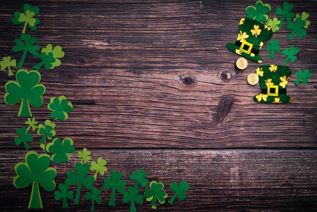 St Patricks day, golden coins, festive hat and green Shamrocks on wooden