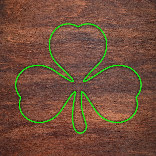 Foto st patricks day groene klaver omtrek is getekend op een houten oppervlak klavertje drie