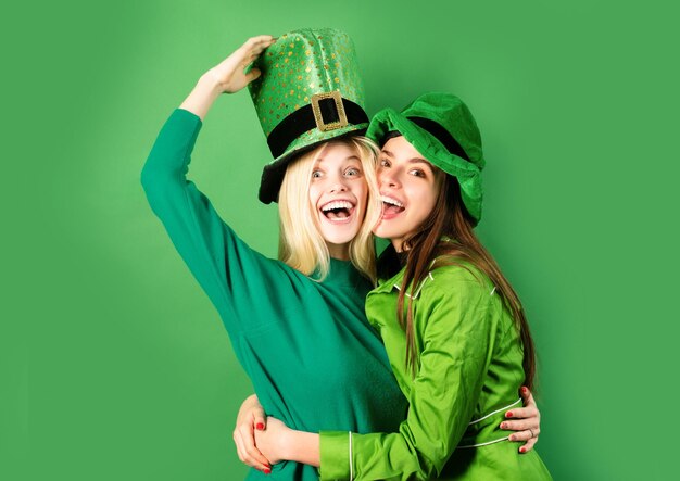 Photo st patricks day two girls in a wig and a cap in bar celebrating concept having fun