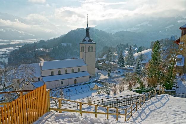St. Theodul parochiekerk en de plaatselijke begraafplaats hieronder. District Gruyère in het kanton Fribourg, Zwitserland
