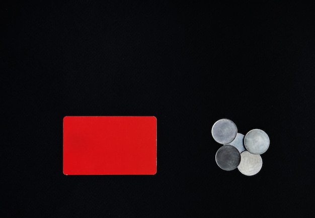 St. Valentijnsdag concept. Een horizontale rode rechthoek en geldmunten op een zwarte achtergrond. Rand, kopie ruimte, bovenaanzicht, feest, vakantie