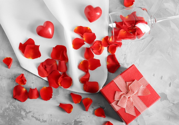 St Valentijnsdag concept Geschenkdoos bloemblaadjes en leeg wijnglas op tafel
