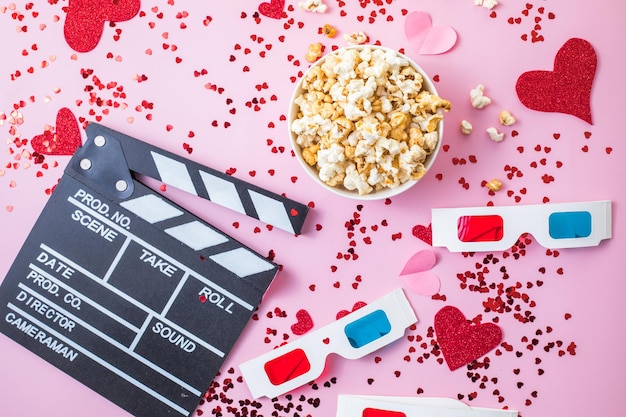 St. Valentijnsdag Movie night concept. Popcorn, 3D-bril klepel bord op roze achtergrond. Gezellige vakantieplannen voor geliefden