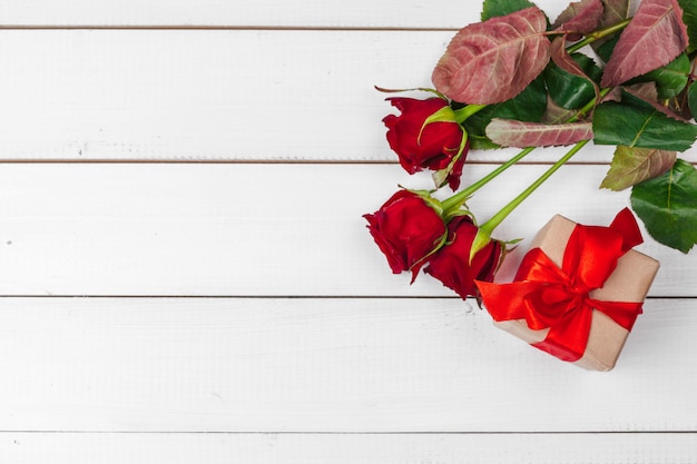 St, Valentijnsdag, rode rozen en geschenkdoos op houten tafel