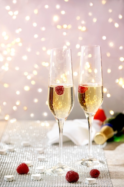 St. Valentine greeting card with two raspberry Champagne glasses on tray standing on silver sparkling table