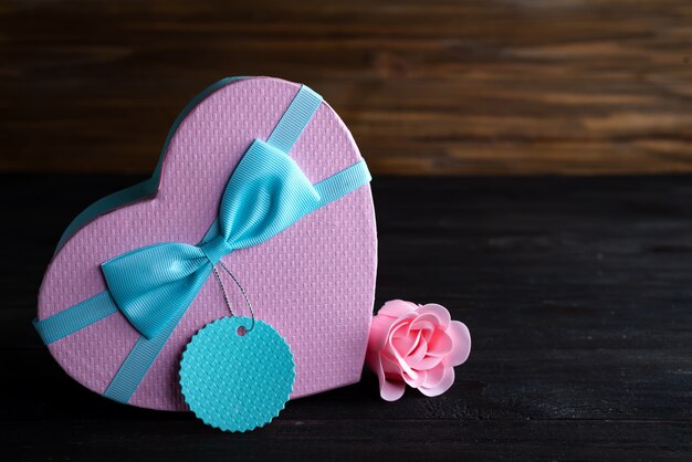 St valentine's day box heart and pink rose on dark wooden background, copy space