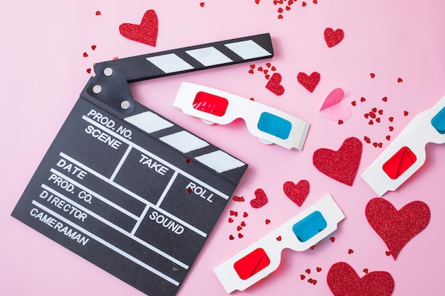 Concetto di notte di film di san valentino. popcorn, batacchio di occhiali 3d su sfondo rosa. piani di vacanza accoglienti per gli innamorati